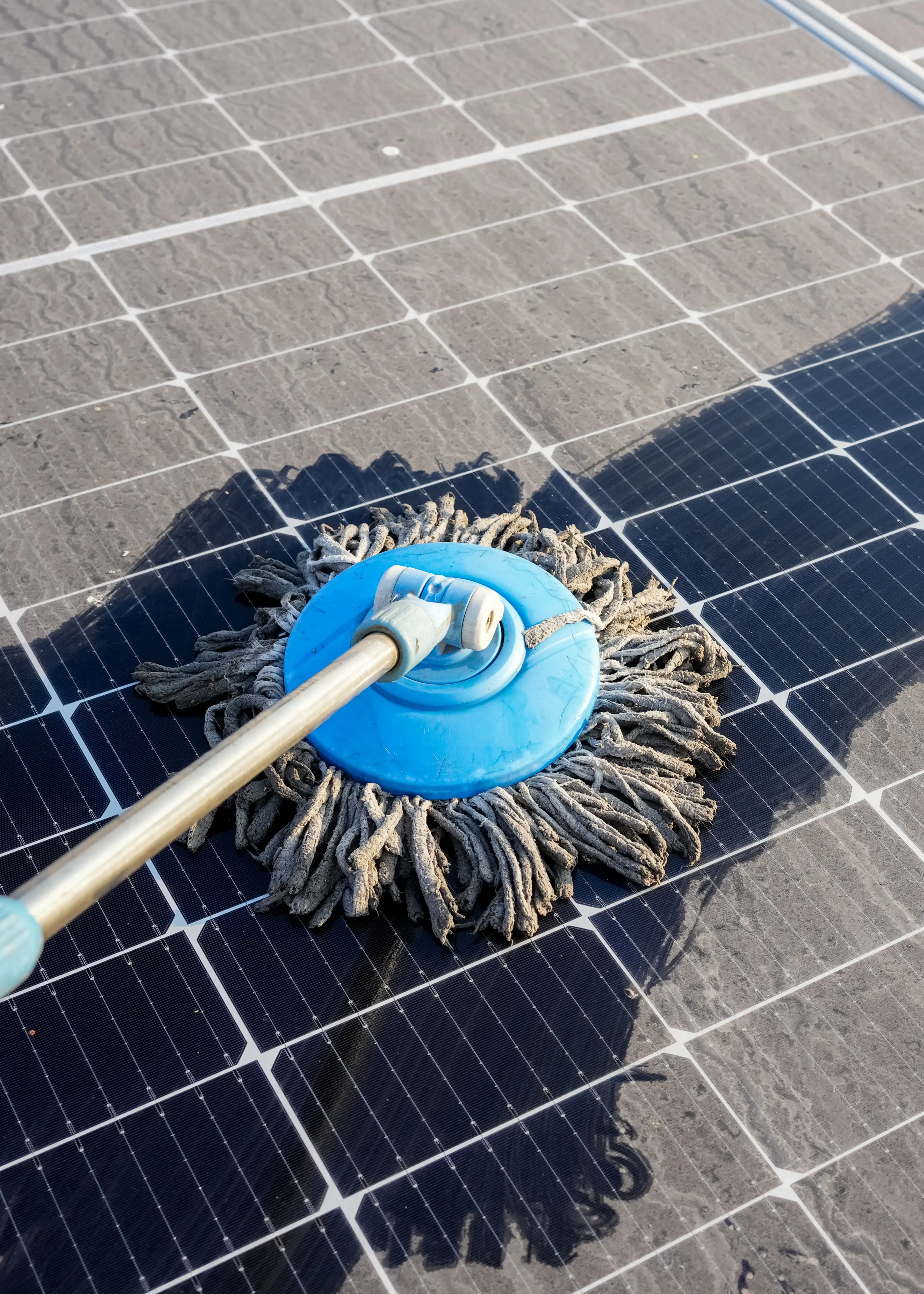 Technician cleaning solar panels covered in dirt and dust, restoring their efficiency with professional maintenance.