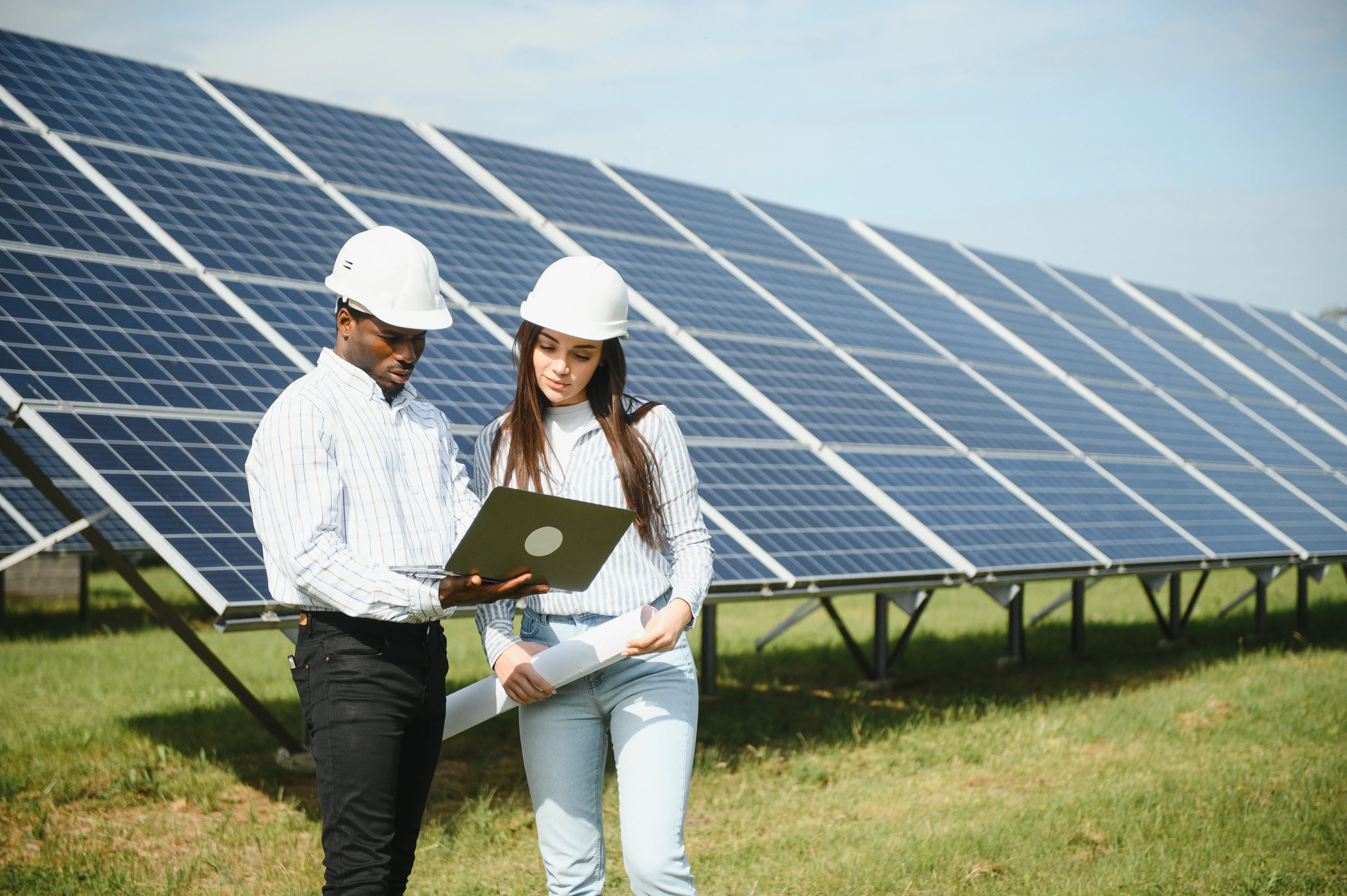 Business professionals reviewing solar energy savings data next to commercial panels